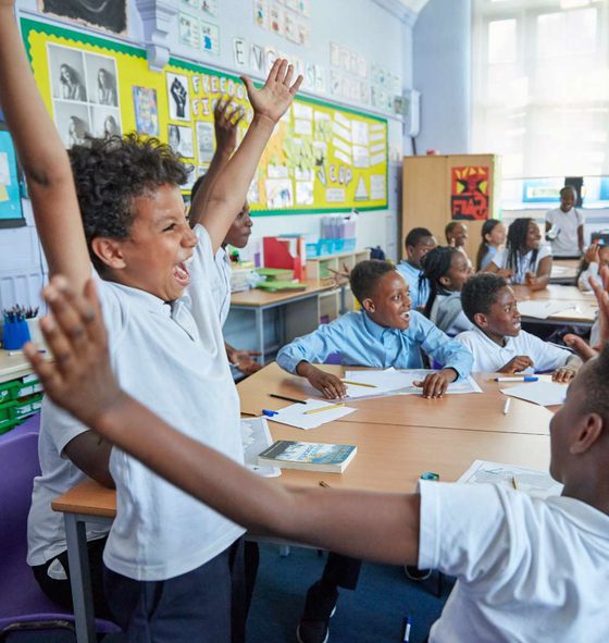 A group of children celebrating in a classom.