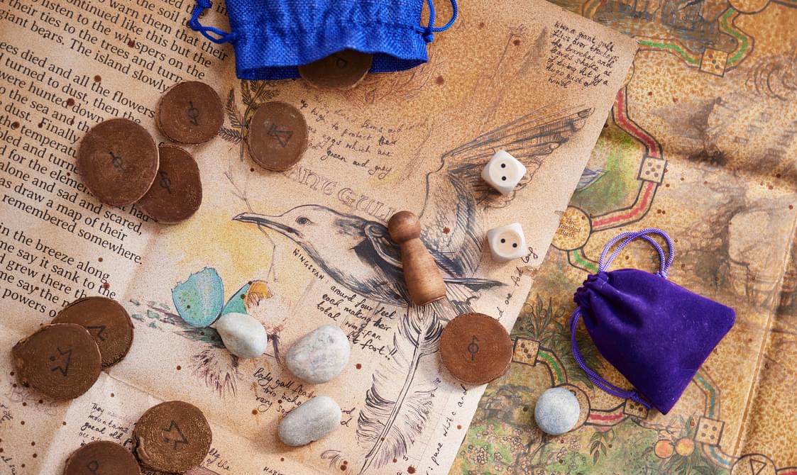 A map of an old board game covered in wooden game pieces and dice.