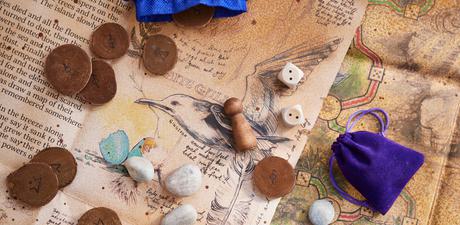 A map of an old board game covered in wooden game pieces and dice.