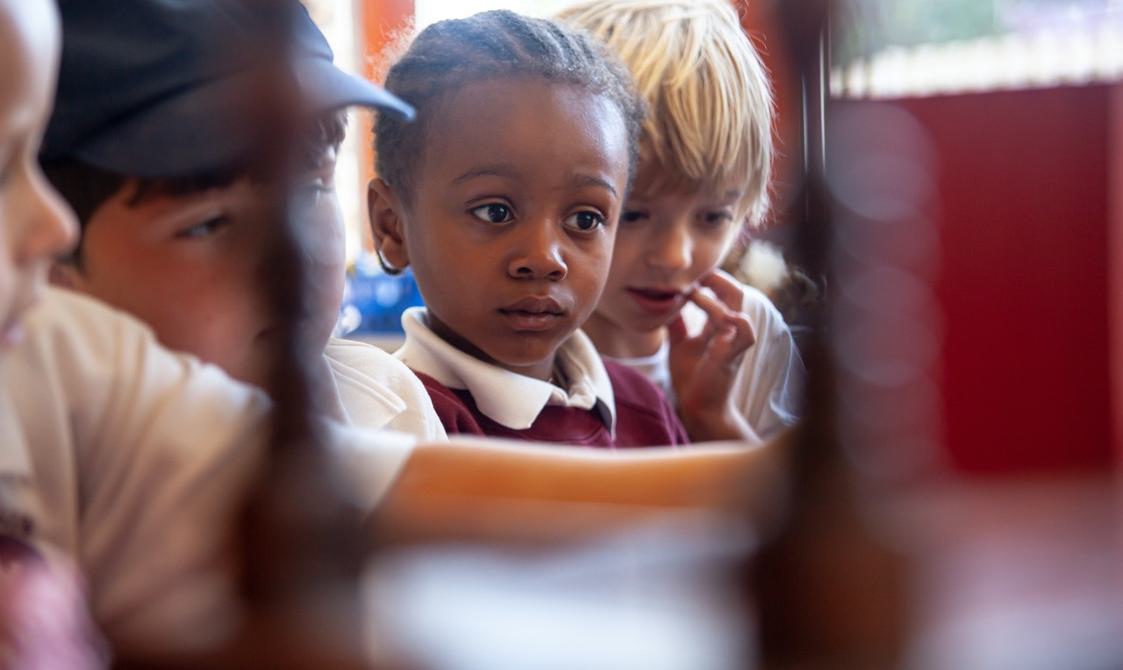 A group of young children looking at the wishing cupboard